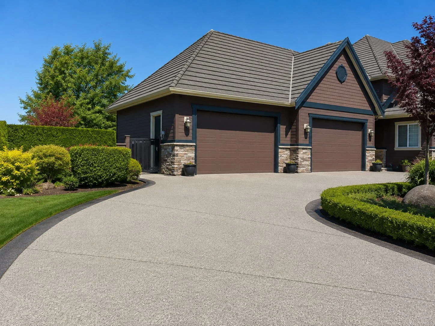 Newly installed exposed aggregate driveway curving to a double garage at a Melbourne home